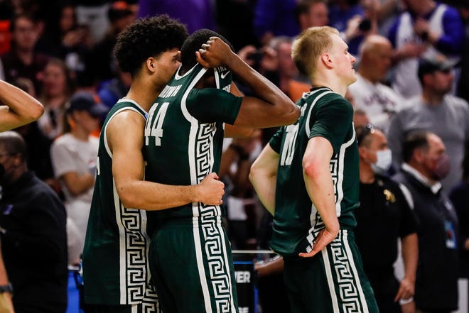 Michigan State forward Gabe Brown, center, is comforted by forward Malik Hall after MSU's 85-76 loss in the second round of the NCAA tournament on Sunday, March 20, 2022, in Greenville, South Carolina.