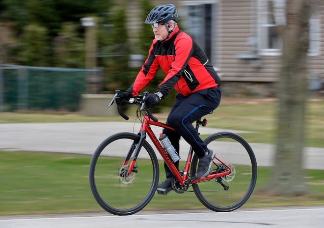 Jon Bock, 51 ans, fait du vélo vers l'est le long de West Lake Road, près de son domicile dans le canton de Girard.