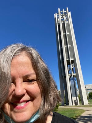 Carillonneur Amy Hamburg is seen in front of the Metz Carillon in the Indiana University Arboretum.