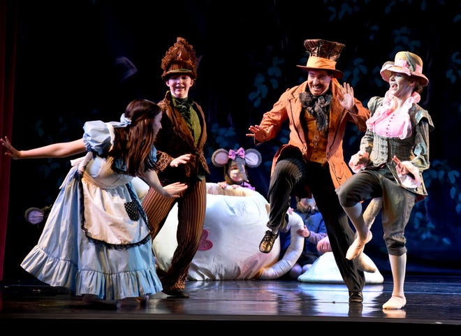 Kynzie Riegel as Alice having fun in the tea party with the March Hare (Emily Bellino), Mad Hatter (Joshua Mohler) and Dormouse (Corinna Aulph) in the production 'Alice in Wonderland' by the River Raisin Ballet Company at the River Raisin Centre of the Arts in Monroe.
