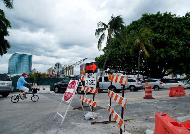 A cyclist navigates construction on South Lake Drive as thunderstorms approach Palm Beach August 4, 2021 in Palm Beach.  MEGHAN McCARTHY/Palm Beach Daily News