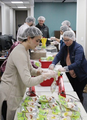 Volunteers package oatmeal in one area of ​​Executive Wealth Management Tuesday, March 22, 2022, food that will be sent to Ukrainian refugees.