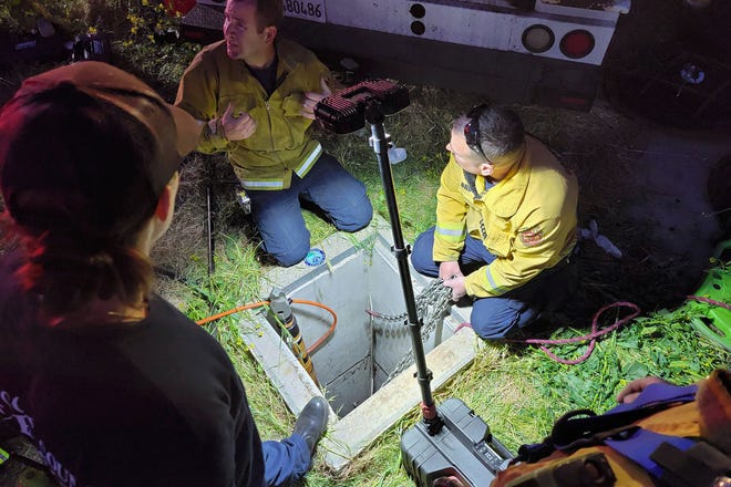 Emergency personnel work on rescuing a man from an underground storm water pipe in Antioch, Calif., Sunday, March 20, 2022. Officials say the man was trapped underground in the storm drain for two days.