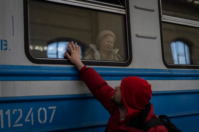 Displaced Ukrainians on a Poland-bound train bid farewell in Lviv, western Ukraine, on March 22, 2022.