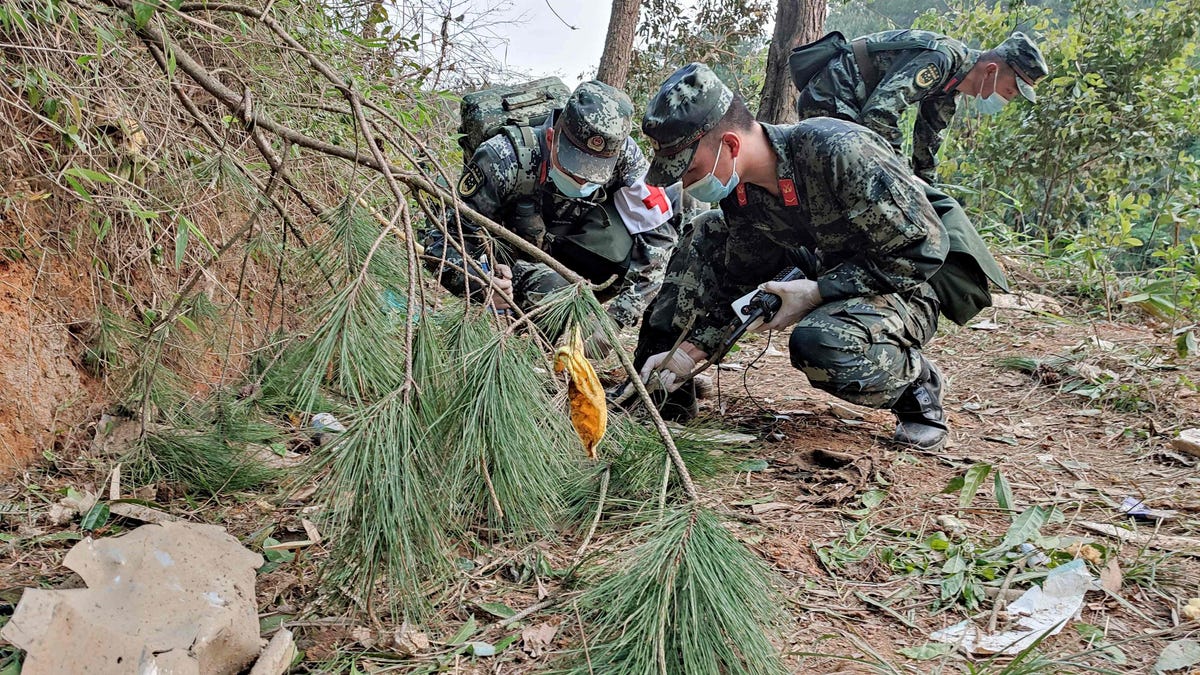 This photo taken on March 21, 2022 shows paramilitary police officers conducting a search at the site of the China Eastern Airlines plane crash in Tengxian county, Wuzhou city, in China's southern Guangxi region.