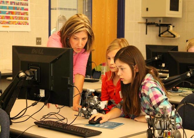 Dr. Elizabeth VanPate guides girls learning to program a robot during the AAUW's Tech Savvy Day in 2017.