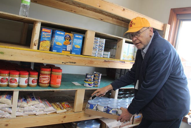 Lou Hoger, site manager, works to stock shelves at the new space for the Perry Area Food Pantry, located at 3112 Willis Ave.