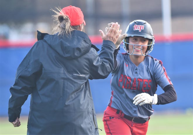 Lubbock-Cooper freshman Alyssa Lozano, right, gets a high-five from coach Sherri Culwell after hitting a solo home run in the second inning against Abilene Cooper.