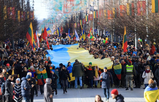 People walk with a giant many meter-long Ukrainian flag to protest against the Russian invasion of Ukraine during a celebration of Lithuania's independence in Vilnius, Lithuania, on March 11, 2022. (Petras Malukas/AFP via Getty Images/TNS)