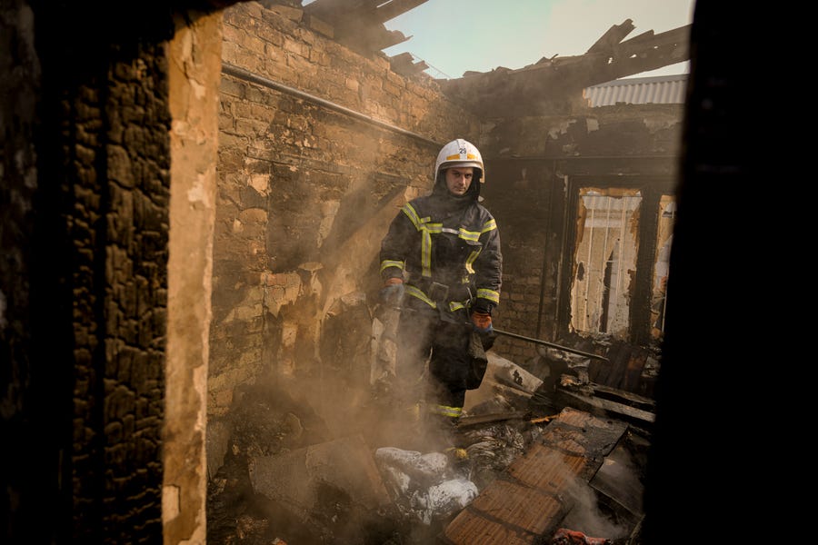 A Ukrainian firefighter stands in the ruins of a house destroyed by bombing in Kyiv, Ukraine, Wednesday, March 23, 2022. The Kyiv city administration says Russian forces shelled the Ukrainian capital overnight and early Wednesday morning, in the districts of Sviatoshynskyi and Shevchenkivskyi, damaging buildings.