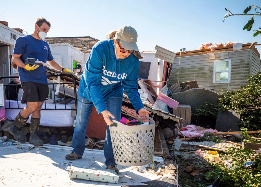 Jane Borrello and her son Colin Labourde salvage belongings after Tornado destroyed house in Arabie, La., Wednesday, March 23, 2022.