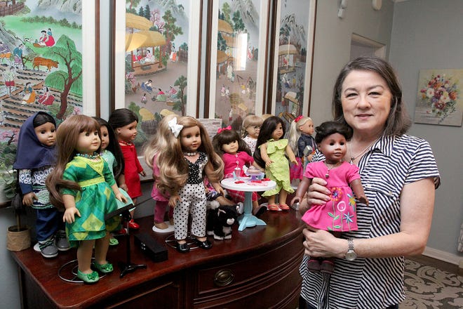 Jeannie Brinkmeier holds one of the refurbished American Girl dolls she's restored on Wednesday, March 16, 2022, at her home in Freeport. Brinkmeier restores the dolls and donates them to organizations that give them to children in need.