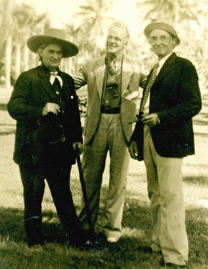 Ward G. Foster, center, talks with James Munroe Munyon, left, and portrait photographer E.W. Histed.