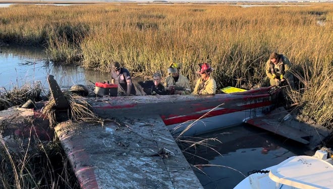 Rescuers work to free pilot Marianne Fox from her plane after it crashed in the marsh south of the Northeast Florida Regional Airport on March 2, 2022.