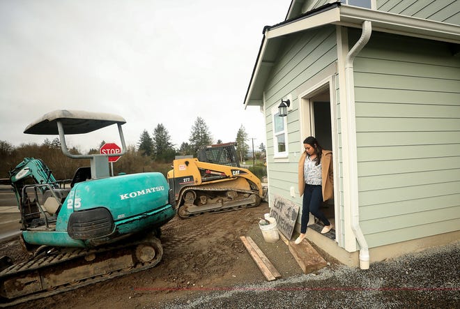 Sherrel Aguon exits her home under construction in Housing Kitsap's Sherman Ridge development in Port Orchard on March 24. Aguon and her neighbors are helping to build their own new homes as part of Housing Kitsap's Mutual Self-Help Housing program.