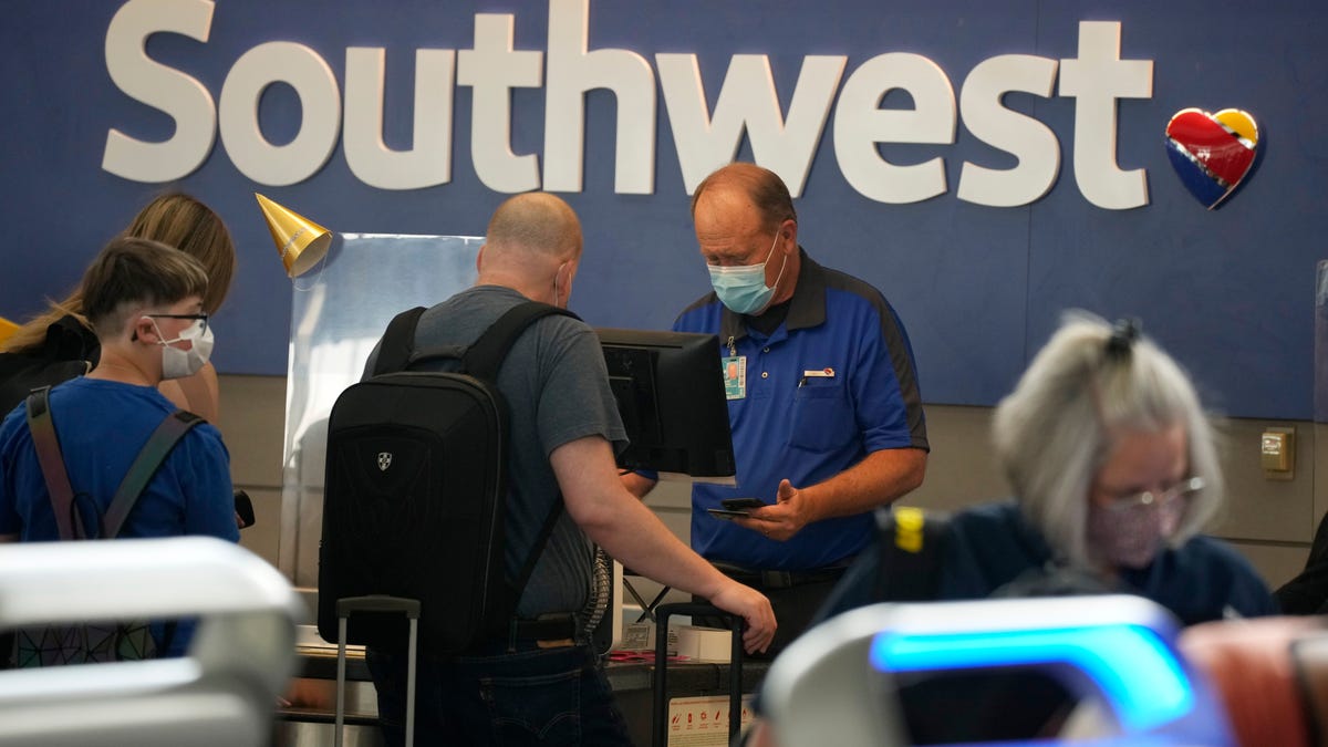 Southwest Airlines ticketing agent helps a traveler at the check-in counter at Denver International Airport in Denver.