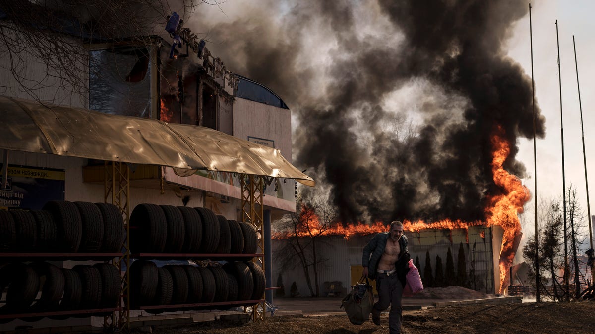 March 25, 2022: A man recovers items from a burning shop following a Russian attack in Kharkiv, Ukraine.