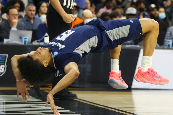 Matthew Lee does a kip-up to get off the court in the second half of the Peacocks' 67-64 win against Purdue.