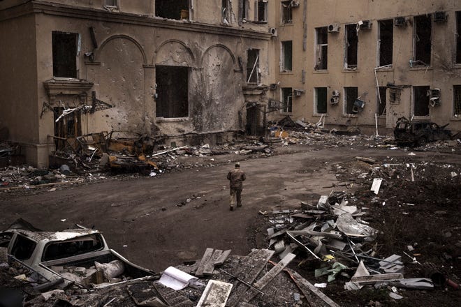 El domingo 27 de marzo de 2022, después del ataque ruso a la ciudad ucraniana de Kharkiv a principios de este mes, un soldado ucraniano camina frente al edificio de la administración regional.