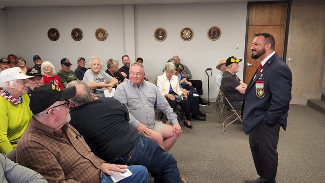 Carlos Pena, veteran and board member of the Texas Panhandle War Memorial Center, talks to veterans attending Tuesday during the Vietnam Veterans Day Event.