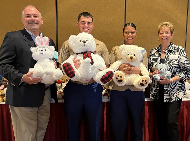 Armed Services YMCA Twentynine Palms Director Patrick Byrne, Marines Xavier Peter and Mary Torres and Charity Chair Donna Kendig show off some teddy bears at the World of Women's fashion show luncheon on March 21, 2022.