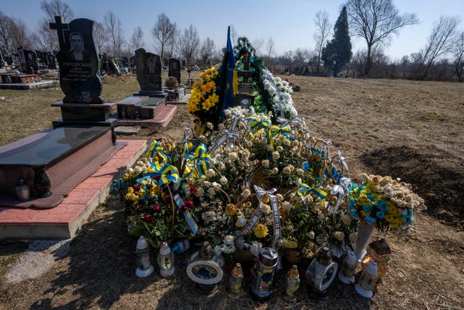 The grave of 25-year-old soldier, Roman Pavlovych, who was killed near the besieged city of Mariupol at a cemetery in Hordynia village, western Ukraine.