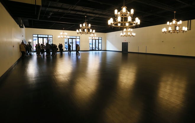 Members of the media take in the former grand ball room during a media tour of House Three Thirty before the public open house in Akron.