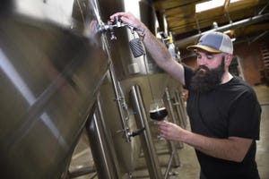 Savannah River Brewing Co. head brewer Adam Fulmer pours beer from one of their eight fermenters.