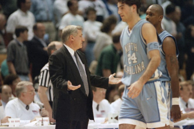 North Carolina coach Dean Smith gestures as Dante Calabria (24) walks past following a scuffle between North Carolina's Rasheed Wallace and Kentucky's Andre Riddick during the first half of the NCAA Southeast Regional championship on Saturday, March 25, 1995 at the Birmingham-Jefferson Civic Center in Birmingham, Ala. North Carolina won 74-61. (AP Photo/Dave Martin)