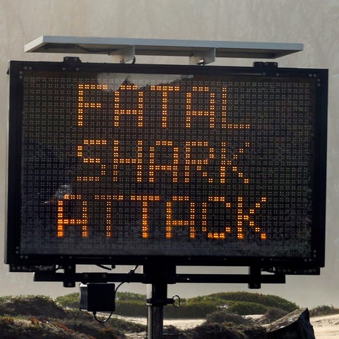 A sign advises about a shark attack, Friday, Dec. 