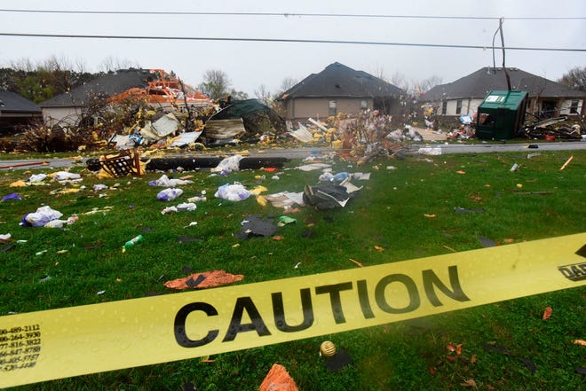Debris litters a neighborhood in Springdale, Arkansas, following a reported tornado that damaged homes and businesses and downed power lines.