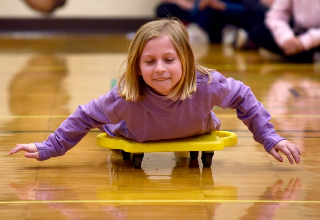 North Elementary third grader Ellie Gratowski rides a scooter in a skeleton race last week. Gratowski was one of the students who got to participate in her school's 'Read for the Gold' Olympic Games after she read for at least 500 minutes in the month of March.