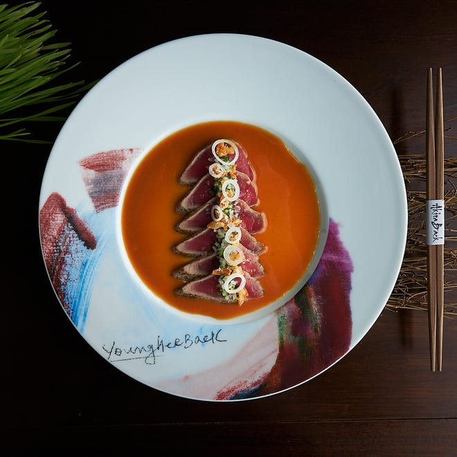 Plato de tataki de atún del chef Akira Pak cubierto con salsa de mostaza y wasabi en escabeche. El plato se representa aquí en un plato diseñado por la madre del chef, el artista Young Hee Bak.
