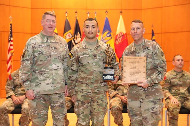 Spc. Adrian Ramirez, center, was named this year's Best Soldier in the North Carolina National Guard Best Warrior Competition and is congratulated by Maj. Gen. Marvin Hunt and Command Sgt. Maj. Benjamin Garner.