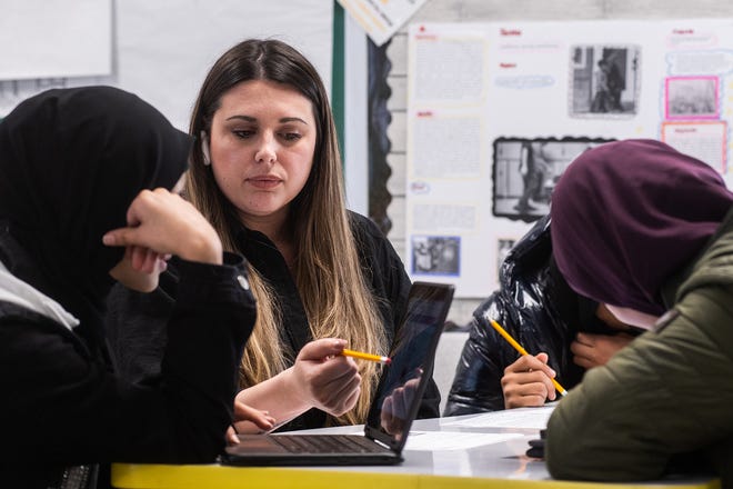 Alyssa Cruz, a South Middle School social studies teacher, talks to her students while their earpieces translate in real-time during class.