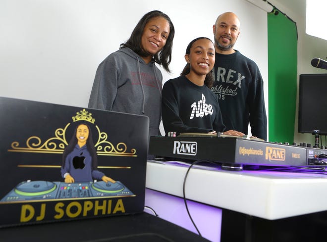 Sophia Clayton stands with her parents, Nicole and David Clayton, at the DJ station where she can perform remotely from her Dover-area family home's living room, a few days before she plays Madison Square Garden on April 2, 2022.