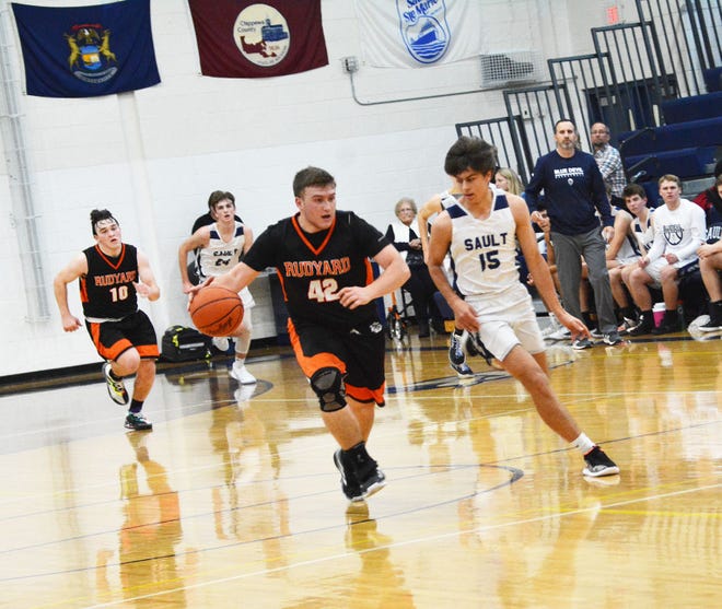 EJ Suggitt of Rudyard (42) drives downcourt while Sault High's Reilly Cox (15) defends in a boys basketball game from this past season. Suggitt was named to the All-UP First Team in Division 4 for a second straight year.