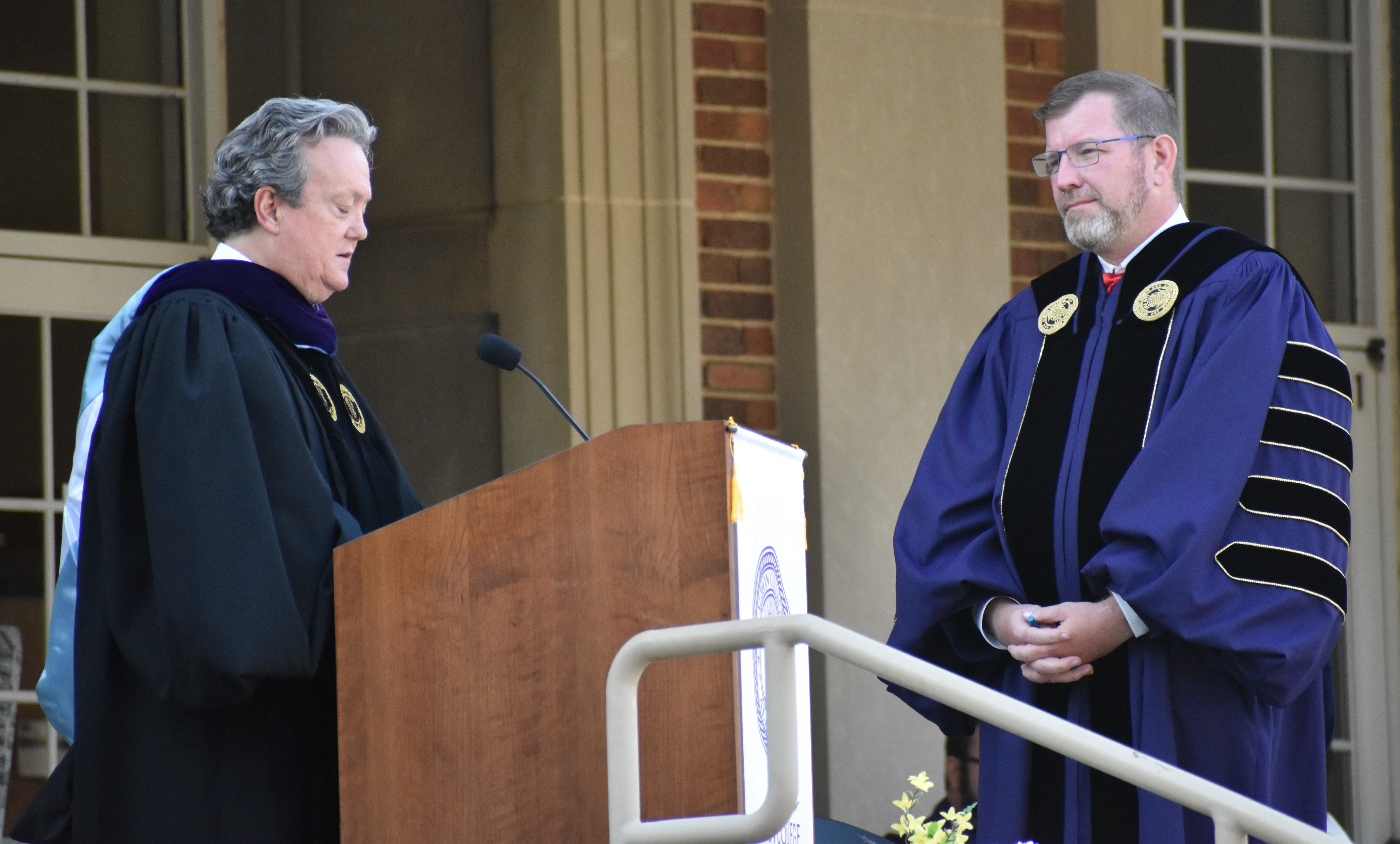 Mathew Johnson, then the president of Albion College, listens to Michael Harrington, then the chairman of Albion College's Board of Trustees, during an inauguration ceremony in September 2021. A few months later, both men had resigned their position.