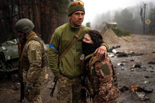 Tentara Ukraina, Igor, 23, memeluk istrinya Dasha, 22, setelah penyisiran militer untuk mencari kemungkinan sisa-sisa pasukan Rusia setelah penarikan mereka dari desa-desa di pinggiran Kyiv, Ukraina, Jumat, 1 April 2022.