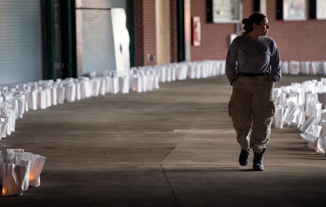 Alyssa De Las Salas walks through a sea of 1,488 luminaries during A Time of Remembrance & Light: A COVID-19 Memorial Event at PeoplesBank Park in York Thursday. The number of luminaries represents the number of people who have died from the Coronavirus since the pandemic began. De Las Salas had a close elderly friend on a ventilator for two months due to virus and she recovered.