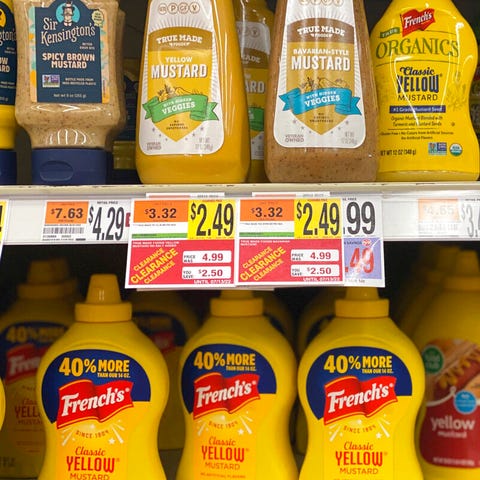A variety of mustards appear on a grocery shelf in