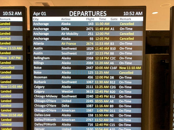 A departure board at Seattle-Tacoma International Airport shows several Alaska Airlines cancellations on April 1, 2022.