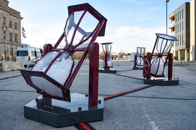 Four of the six giant hourglass modules as part of a temporary interactive art installation "LAPS: A Journey Through Time - Here and Now" are seen along Robert D. Ray Drive on Friday in Des Moines.