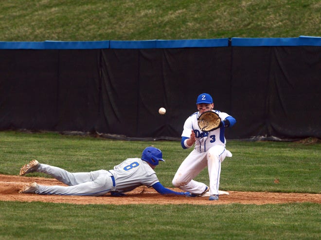 Zanesville's Trey Whiteman takes a throw from the pitcher as Philo's Griffin Wells dives back into first base during a game earlier this season. Whiteman made the East District first team.