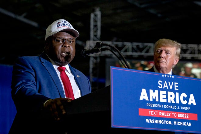 John Gibbs, candidate for U.S. Representative from Michigan’s 3rd District and Former Acting Assistant Secretary of Housing and Urban Development, left, speaks while on stage with Former President Donald J. Trump during the Save America Rally at Michigan Stars Sport Center in Washington Township, Mich. on April 2, 2022.