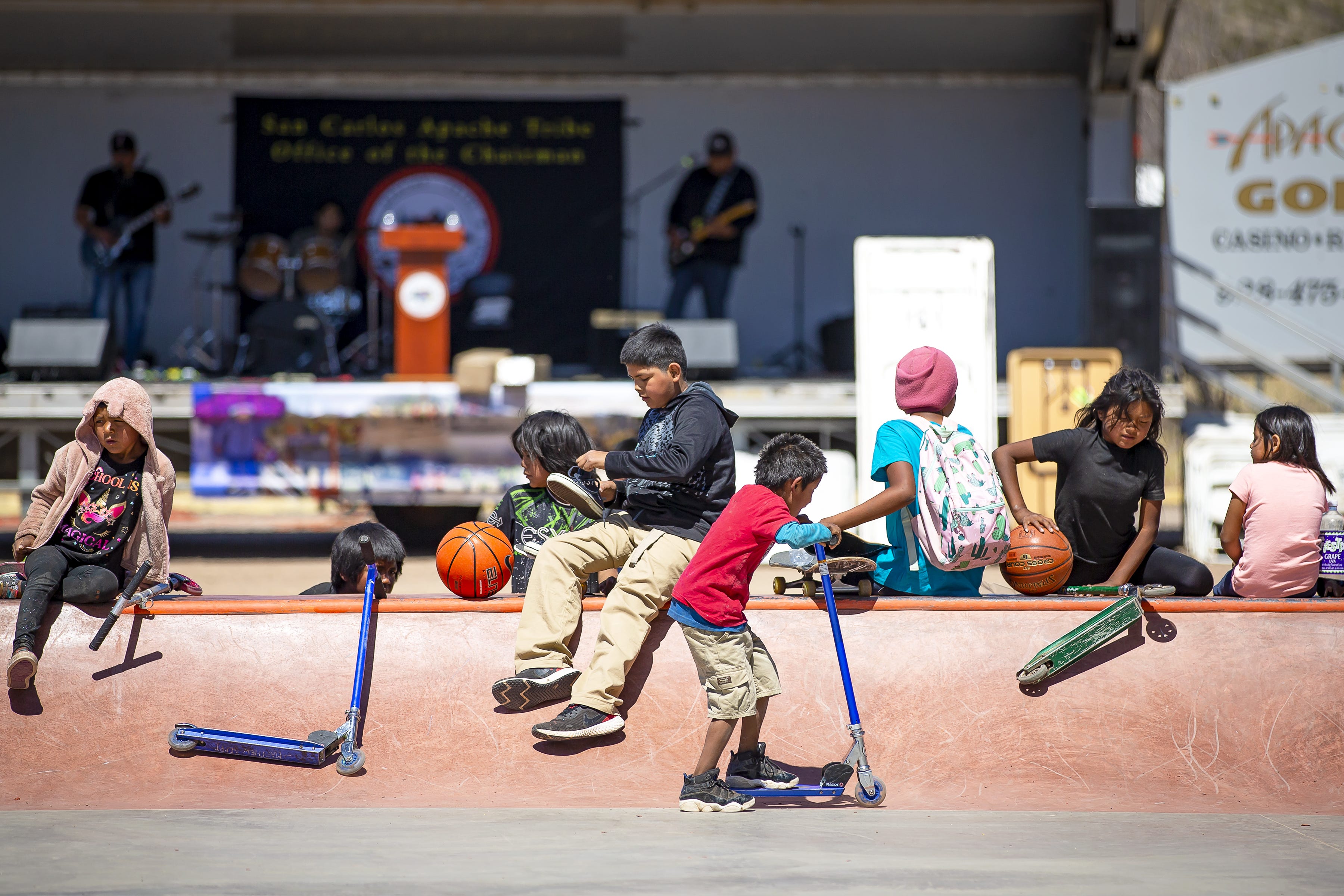 A group of children sit on a ledge at the new skate park in San Carlos on April 1, 2022.