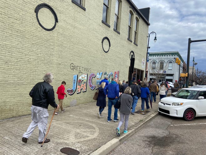 The group of about 40 who took the walking tour of Downtown Jackson on April 2, 2022, walk by the Jackson mural at Come Unity Cafe.