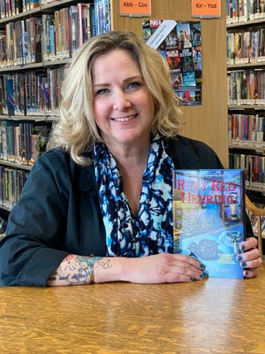 Author Tracy Gardner shows off her first book in the Avery Ayers Antique Mystery series, Ruby Red Herring, on Saturday, April 2, at the Howell Carnegie District Library. Gardner will come out with her second book in the series on June 7, 2022.