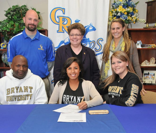 Caesar Rodney senior Chaney Jones signs a letter of intent to play softball at Bryant University. She is surrounded by parents Avon and Nicole (seated) and coach Peter Moran, school principal Sherry Kikowski and coach Casey Shelor.
