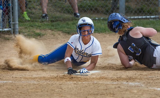 Caesar Rodney's Chaney Jones slides safely into home after colliding with Charter catcher Emily Smith in a playoff game on May 24, 2014.